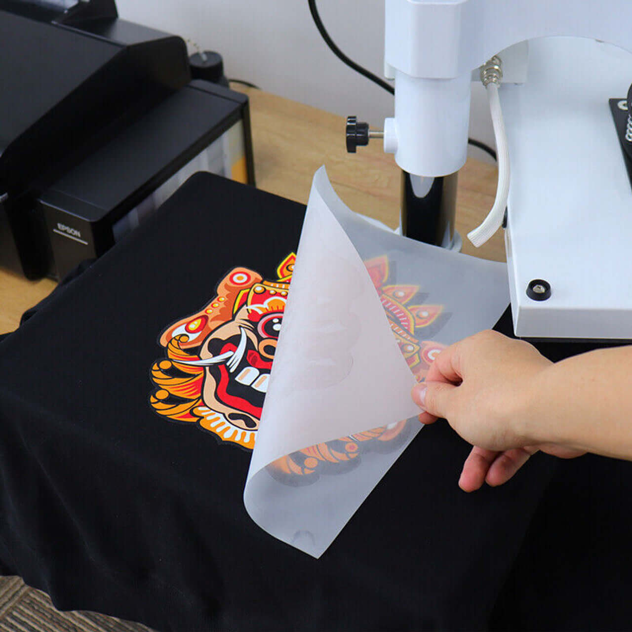 Applying DTF transfer to a black T-shirt using a heat press machine for vibrant prints in Weston Florida.